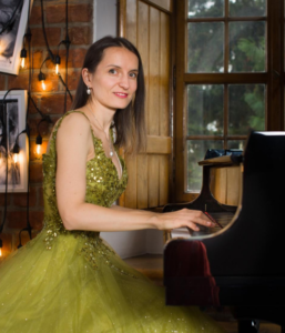Aleksandra Hurkała – pianistka przy fortepianie podczas koncertu Chopina w Warszawie. Portret artystki w zielonej sukni, Chopin Point Warsaw, Stare Miasto.